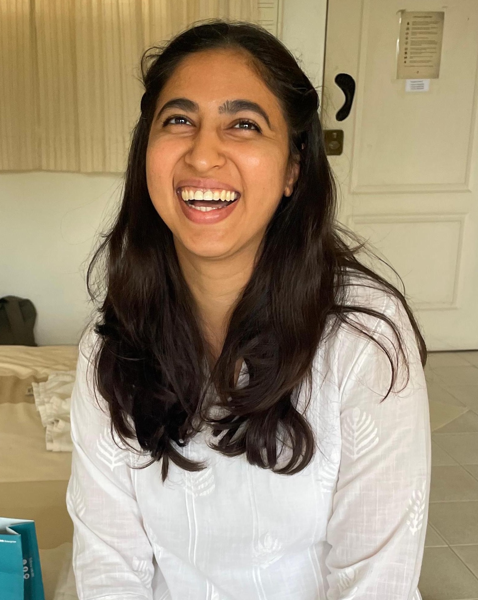 Rasika Sethi laughing, head tipped back.
